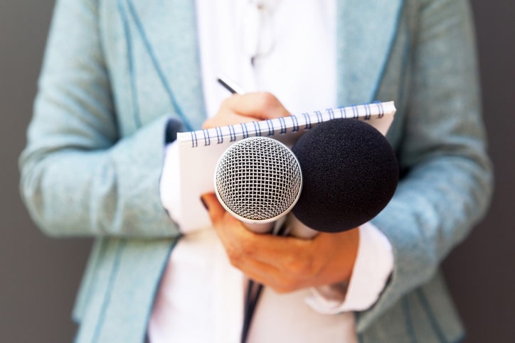 Photo of a journalist holding a mic