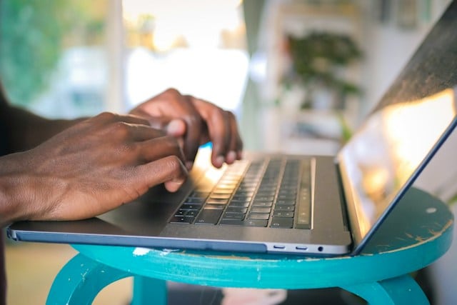 Photo of hands typing on a laptop