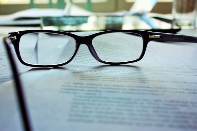 Photo of a pair of reading glasses on top of a report or book.