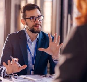 Photo of two professional people having a discussion in an office environment.